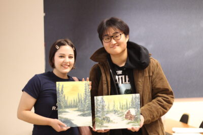Two students showing off their completed artwork.