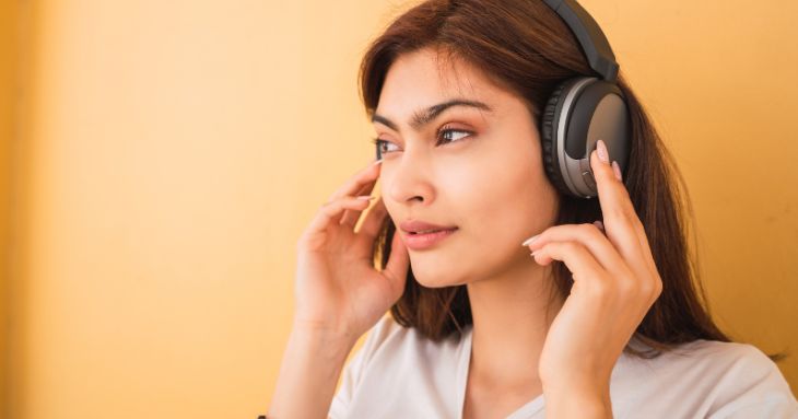 ヘッドホンで音声を聞く女性