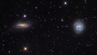 two swirls of colorful light on a starry background