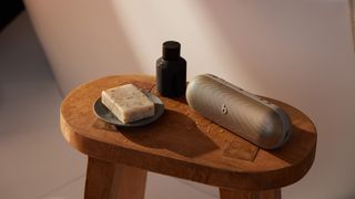 Beats Pill en couleur champagne, sur une table avec de l'eau de Cologne