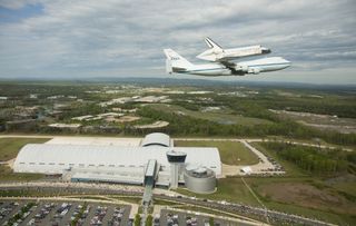 Space shuttle Discovery, mounted atop a NASA 747 Shuttle Carrier Aircraft (SCA) flies over the Steven F. Udvar-Hazy Center, Tuesday, April 17, 2012, in Washington.