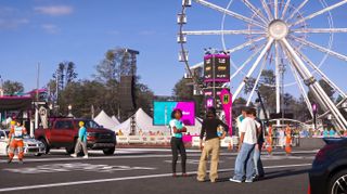 A screenshot of Forza Horizon 6 characters talking at the Horizon Festival outpost.