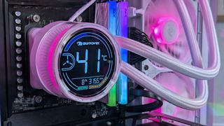 Close-up of iBUYPOWER RDY Trace X R01 pre-built gaming PC's internal cooling system with a digital display reading 41°C. Radiant lighting and sleek cables exude a high-tech, vibrant ambiance.