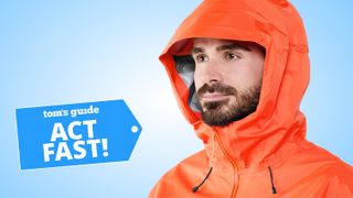 Close-up of a model wearing the Arc'teryx Beta SL rain jacket in orange