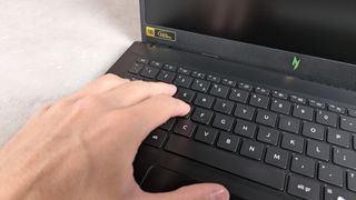 Fingers on keyboard of Acer Nitro V 15