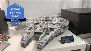 A Lego space ship in the shape of a disk at the rear and two pointed parts at the front is sitting on a white desk with the space.com logo in the top left corner.