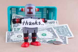 A toy robot with the word "Thanks" written on paper standing in front of basket of money.