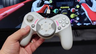A prototype of the GameSir TR640 game controller in white with Assetto Corsa in the background.