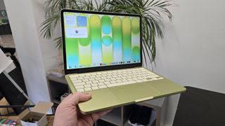 MacBook Neo laptop on a desk with plant in background