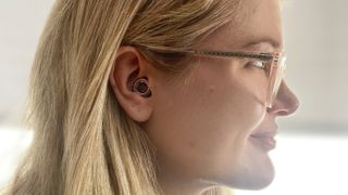 A photo of TechRadar writer Becca Caddy wearing the Loop Experience earplugs