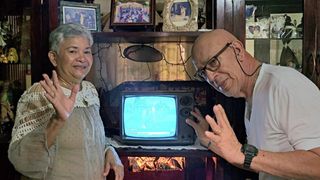 A couple standing in front of their old Samsung CRT TV