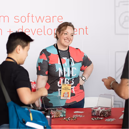 Atomic Object team interacting with attendees at a tech event, showcasing services and community engagement.