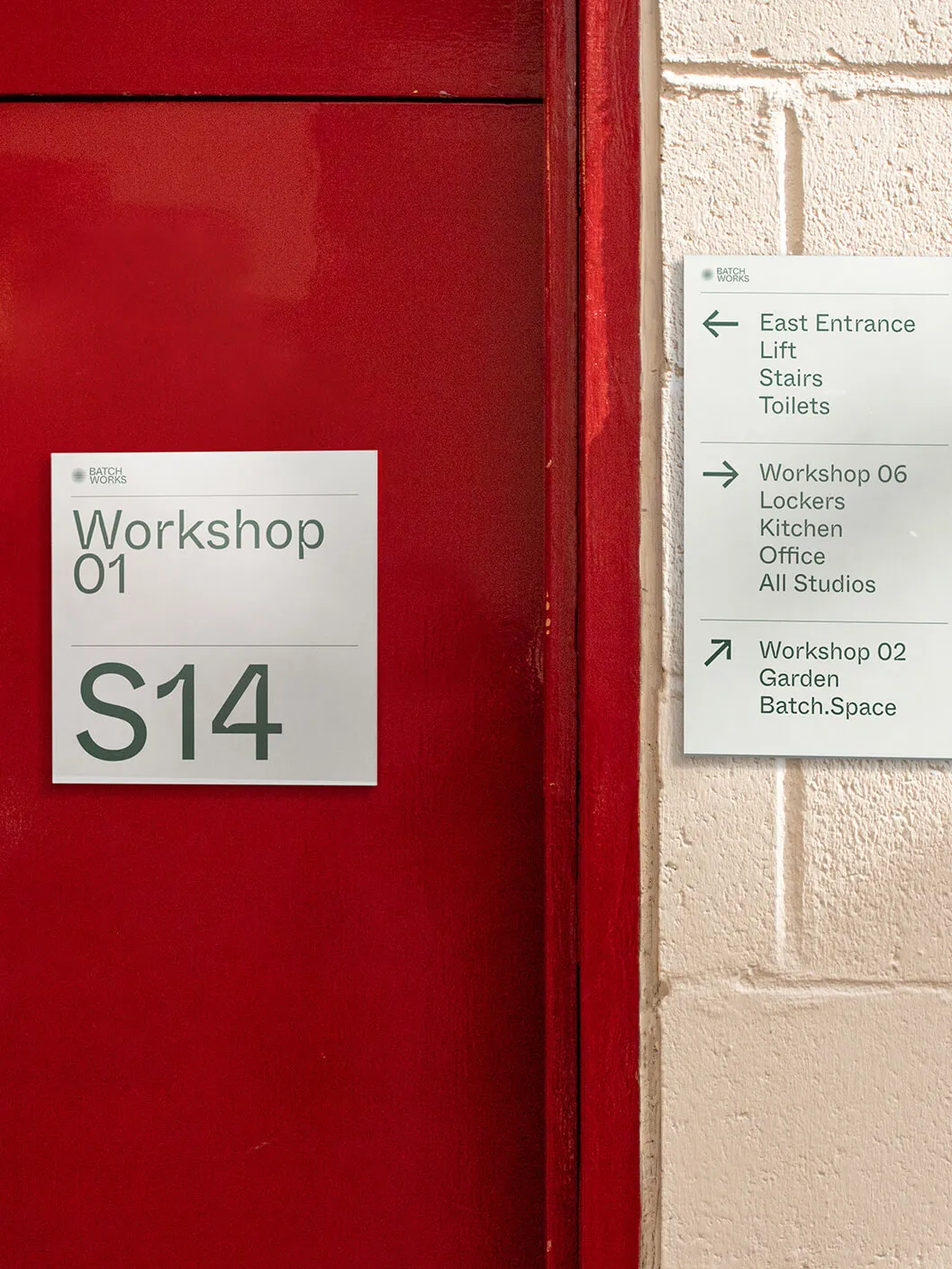 Red door in the Batch.Works workshop with wayfinding graphics and signage design