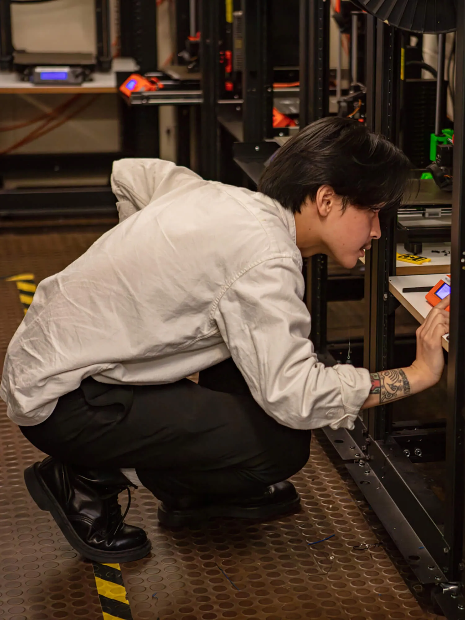 Batch.Works team member looking at a 3D printer in the workshop