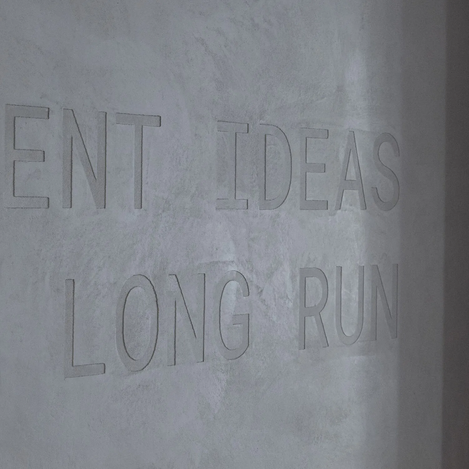 Close up photograph of the details of the engraved text in the curved stone office wall