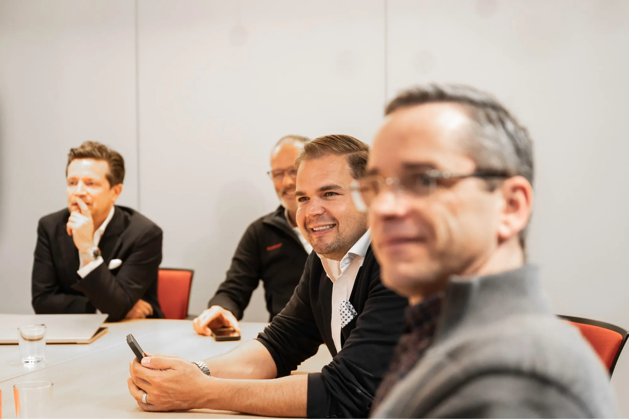 executives sitting at long table smiling