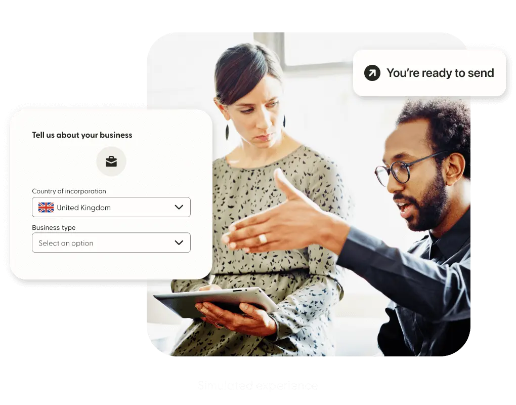 Two professionals discuss beside a simulated Remitly screen.