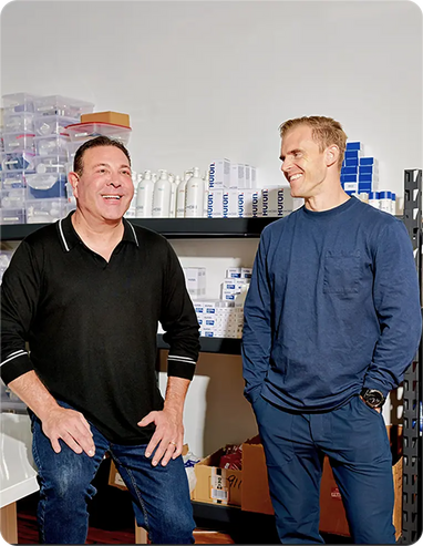 Photo of Huron co-founders standing next to each other featuring Huron products in the background.