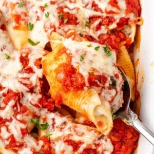 stuffed shell on spoon in dish.