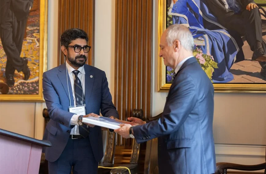 Vikram Chadalawada hands the group's final report to U of T President Meric Gertler.