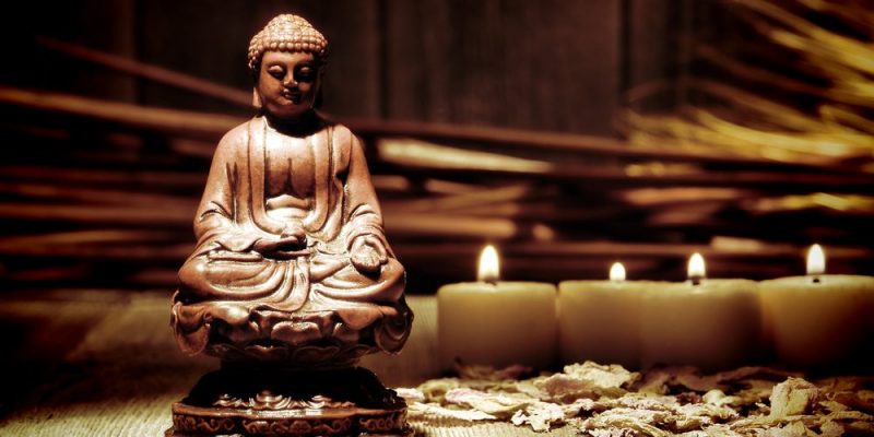 Escultura de Buda junto a velas encendidas