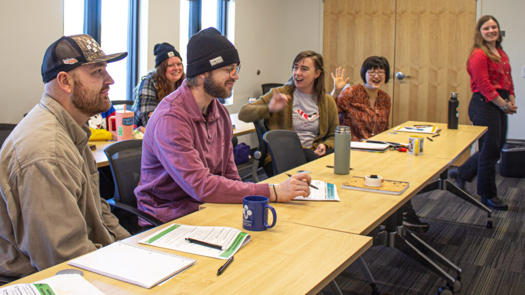Seven support professionals sitting at a table during a training