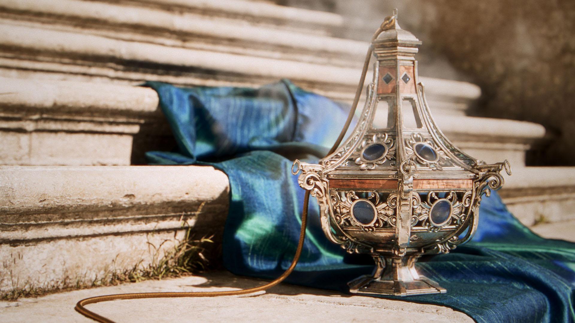 A lamp and a piece of satin cloth placed on stone stairs