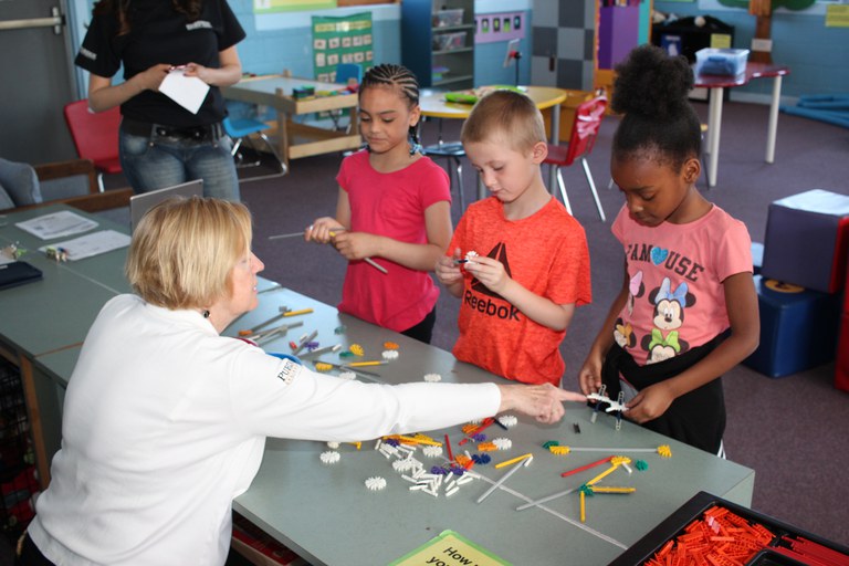 Mentor_Guide Adult helping children build with toys