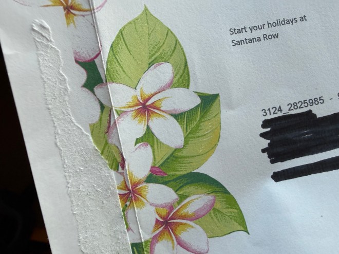 Close-up of a partially torn envelope featuring floral designs with white flowers and green leaves, alongside the text 'Start your holidays at Santana Row'.