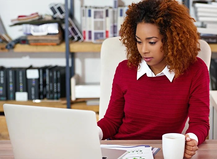 A woman on laptop uses skills from her project management microlearning course at NMSU Global Campus