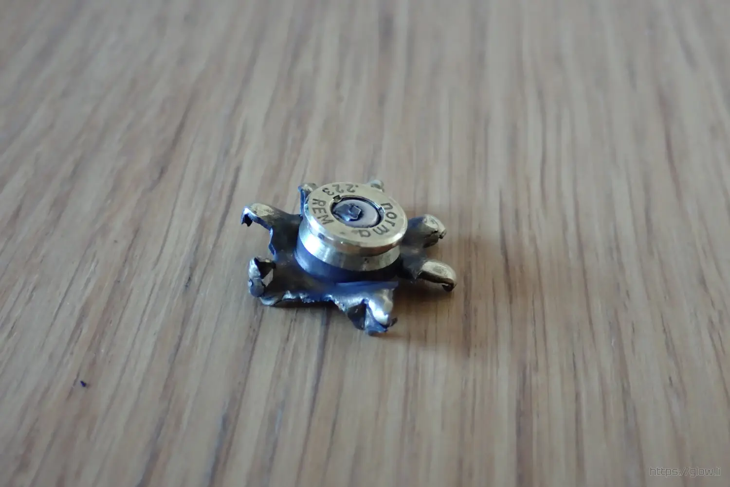 A broken rifle cartridge. It has burst and is in the shape of a star A broken rifle cartridge. It has burst and is in the shape of a star