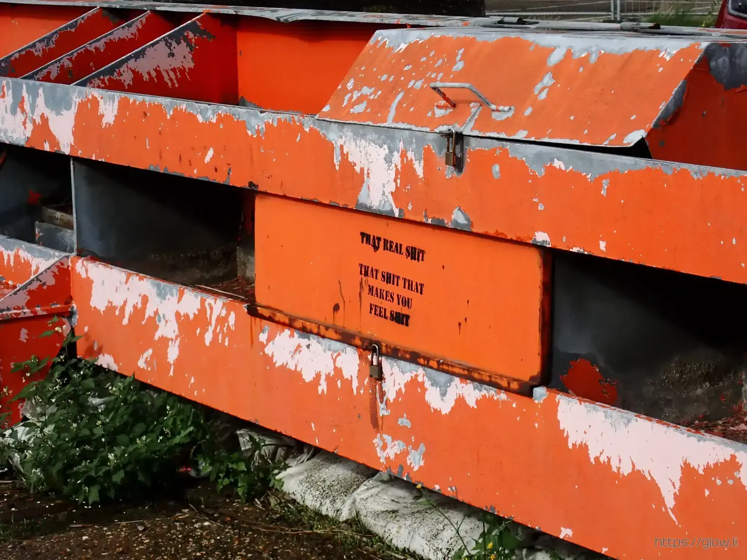 Photo of an orange blockade with a graffiti reading "THAT REAL SHIT; THAT SHIT THAT MAKES YOU FEEL SHIT" Photo of an orange blockade with a graffiti reading "THAT REAL SHIT; THAT SHIT THAT MAKES YOU FEEL SHIT"