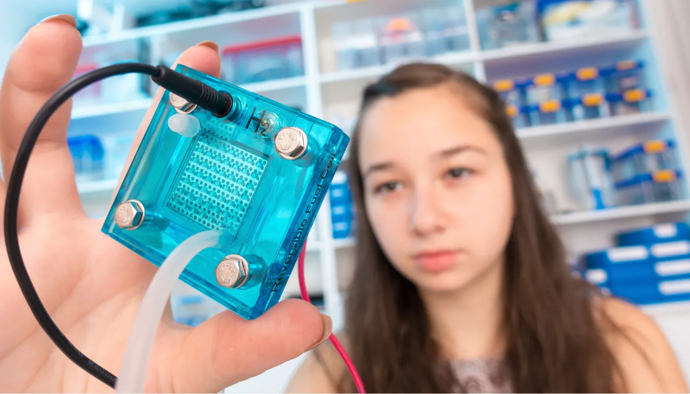 電気分解で水素を発生させる電解槽を持つ女性