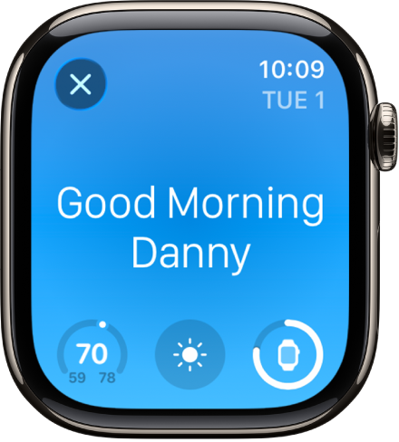 Apple Watch pulkstenis, kurā redzams pamošanās ekrāns. Augšpusē redzami vārdi Good Morning. Zem tiem redzama temperatūra, laika prognoze un akumulatora uzlādes līmenis.