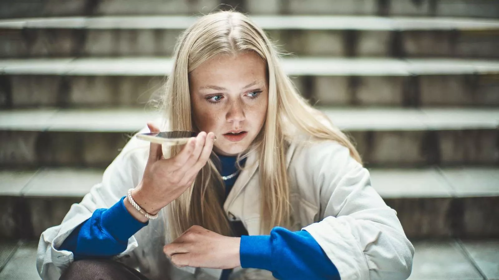 Pige indtaler en memobesked på sin telefon