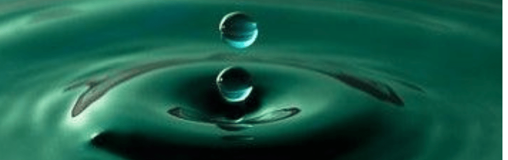 Two drops of water creating ripples in a deep green watery surface