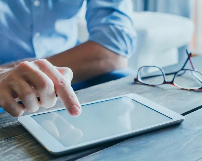 Person touching a tablet with her finger.