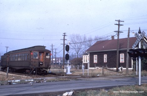 A southbound Westchester train crosses Madison Street in Bellwood, where Marshall Avenue begins today. The house at right is still standing. The Bellwood station was just north of here, near where the line merged back into the CA&E main line. We are just west of Bellwood Avenue.