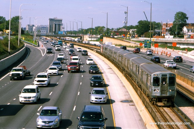We are looking to the west/northwest along the Kennedy expressway at Canfield. An inbound CTA Blue Line train approaches the Harlem Avenue station (located behind the photographer). This picture was taken around October 2019.