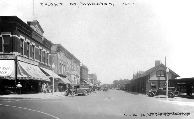 A real photo postcard (postmarked 1930) view of Front Street in Wheaton, looking east from Main Street, including the Chicago and North Western commuter station. It has since been replaced by a newer one nearby, served by Metra's UP-West Line. The Chicago Aurora and Elgin station was just south of here, out of view.