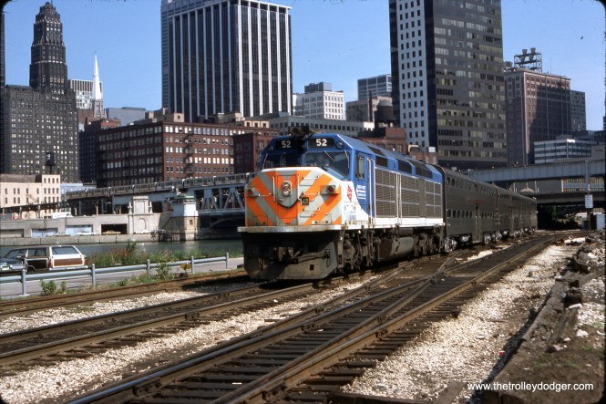 Subject: Metra #52 Diesel Loco Location: Chicago, Illinois Date: June 1977 Photographer: Joseph R. Quinn Here is a classic view of a Metra commuter train in Chicago, having just left Union Station. You can see a Chicago "L" train in the background.