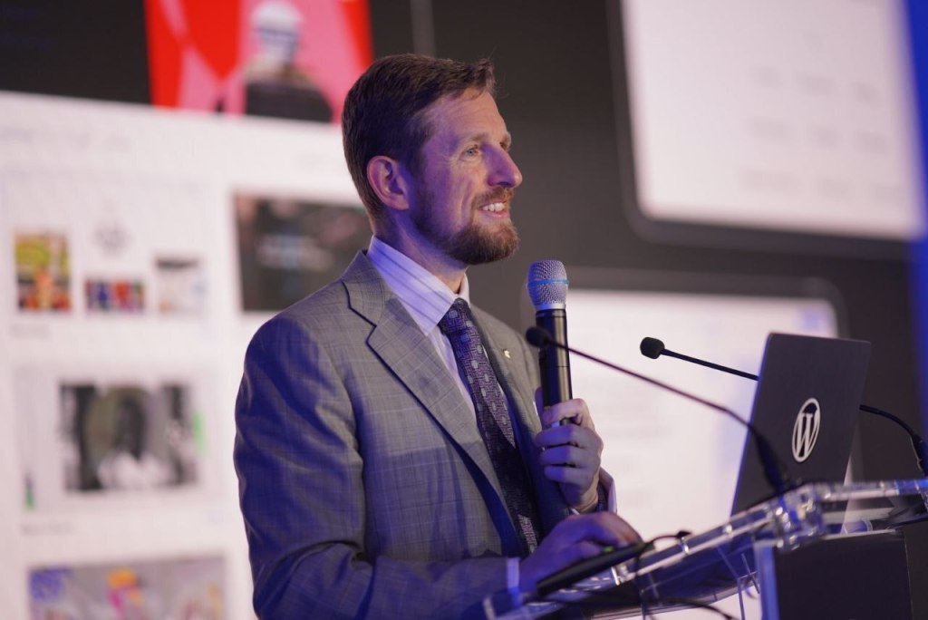 WordPress co-founder Matt Mullenweg speaking at a podium