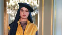 A model walks the runway wearing a headscarf and beret during the Paris Modest Fashion Weeks 2026 by Think Fashion at Hotel Le Marois on April 16, 2026 in Paris, France