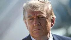 Trump looking at camera in suit.