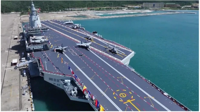 Flight deck of the latest aircraft-carrier of China. Two fighter aircraft stationed at take-off points. There are also two helicopters.