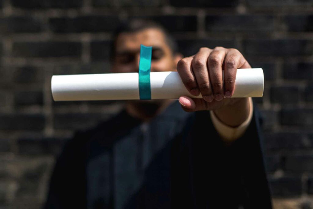 student-outside-holding-out-diploma-web student outside holding out diploma