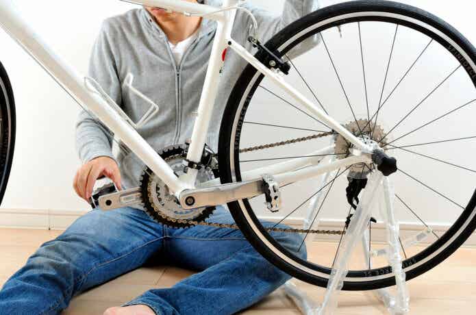 部屋で自転車を整備する男性