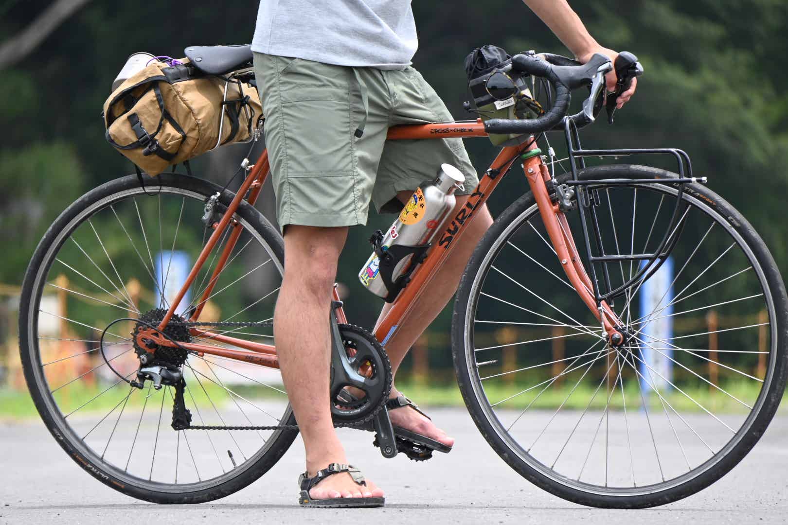 サンダルでロードバイクに乗る男性