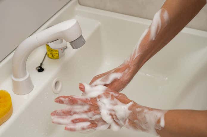 石鹸で手を洗う人