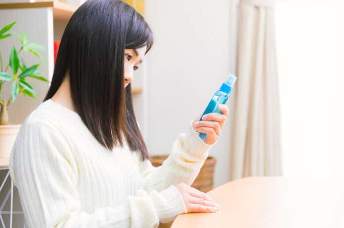 虫除けスプレーの説明書きを注視する女性